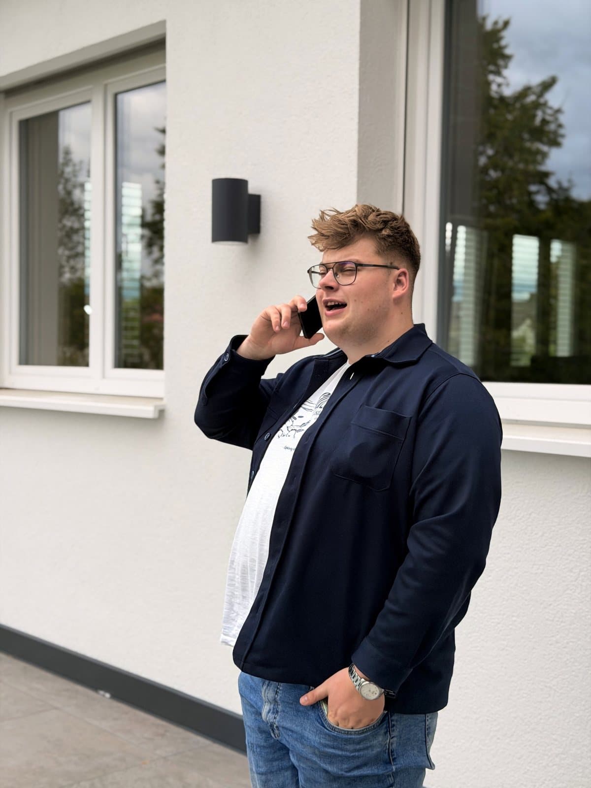 Paul Budde steht vor dem Bürogebäude in Anröchte und telefoniert.