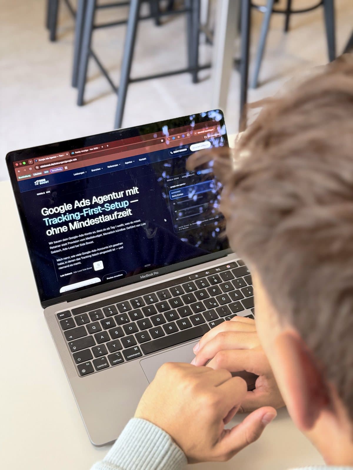 Blick über Luis Sabischs Schulter auf einen Laptop mit der Google-Ads-Seite von Side Boost.