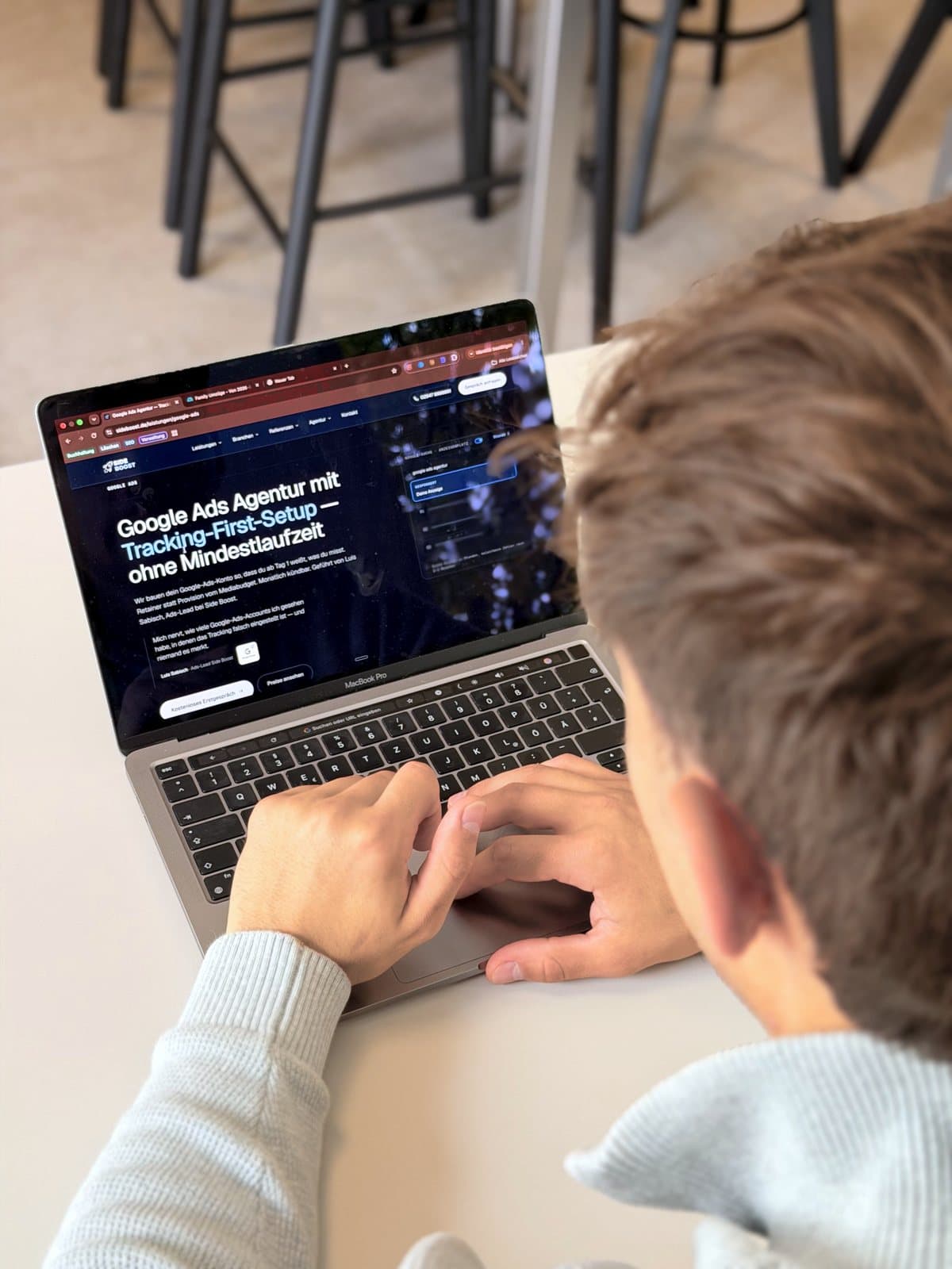 Luis Sabisch tippt mit beiden Händen auf der Tastatur, auf dem Bildschirm die Google-Ads-Seite.