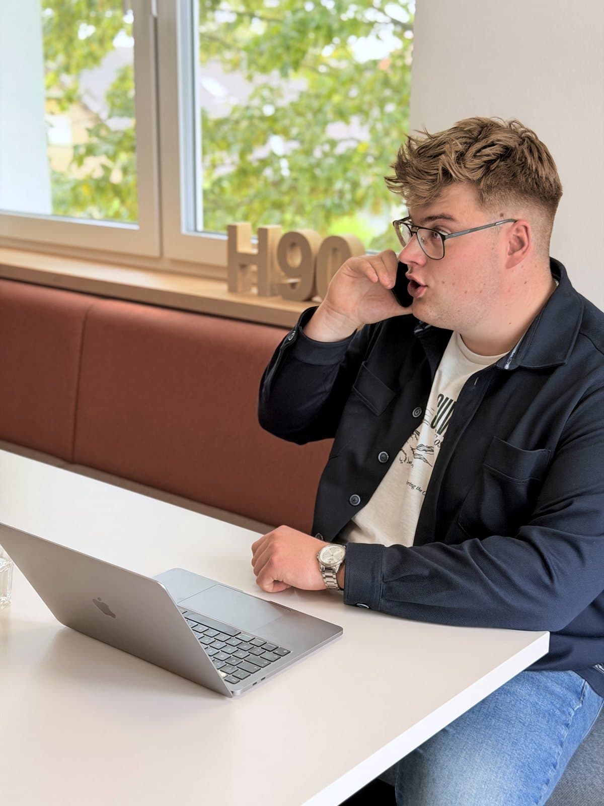 Paul Budde telefoniert und gestikuliert dabei mit der freien Hand.