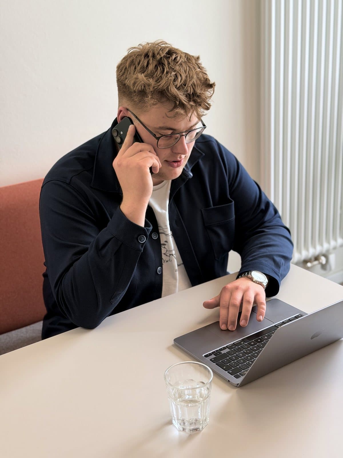 Paul Budde telefoniert und schaut dabei auf den Laptop vor sich.