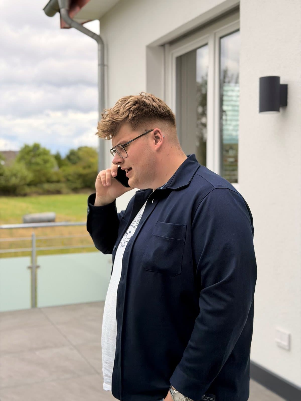 Paul Budde draußen am Telefon, im Profil.